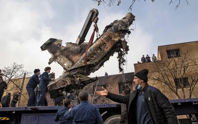 Firefighters put out a blaze at the crash site of a fighter jet which fell in a residential area of Iran's northwestern city of Tabriz on February 21, 2022. (Photo by Maryam Ebrahime/ISNA/AFP Photo)