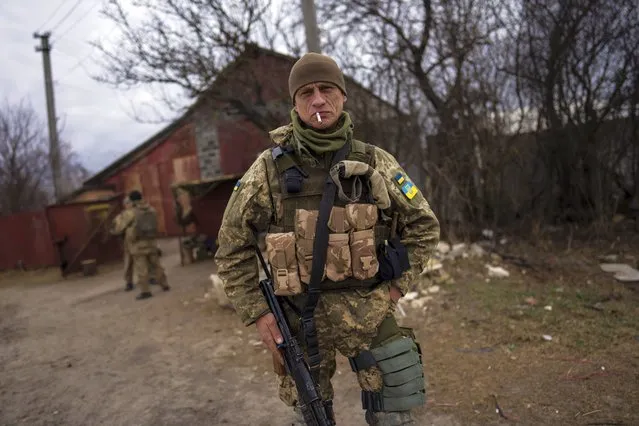 A soldier smokes a cigarette near the frontline in Brovary, on the outskirts of Kyiv, Ukraine, Monday, March 28, 2022. (Photo by Rodrigo Abd/AP Photo)