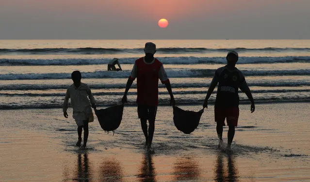 Fishermen return home as the sun sets at the beach in Karachi, Pakistan, 21 November 2019. (Photo by Shahzaib Akber/EPA/EFE)