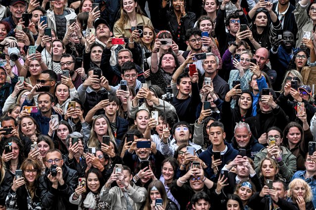 Members of the audience take picture as guests arrive for the screening of the film “Killers of the Flower Moon” during the 76th edition of the Cannes Film Festival in Cannes, southern France, on May 20, 2023. (Photo by Patrícia de Melo Moreira/AFP Photo)