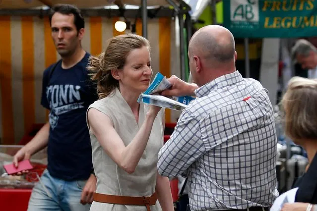 A passerby takes leaflets from the hand of Les Republicains (LR) party candidate Nathalie Kosciusko- Morizet during an altercation while campaigning in the 5th arrondissement in Paris on June 15, 2017, ahead of the second round of the French legislative election. (Photo by Geoffroy Van Der Hasselt/AFP Photo)