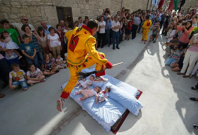 A man representing the devil leaps over babies during the festival of El Salto del Colacho (the devil's jump) on June 22, 2014 in Castrillo de Murcia, Spain. The festival, held on the first Sunday after Corpus Cristi, is a catholic rite of the devil cleansing babies of original sin. (Photo by Denis Doyle/Getty Images)
