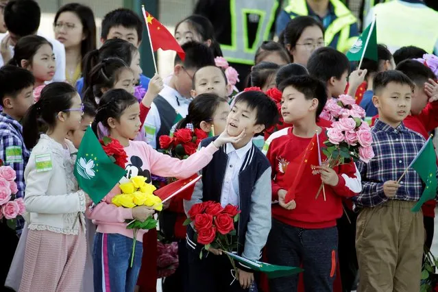 Children holding Chinese and Macau flags get ready before Chinese President Xi Jinping's arrival at Macau International Airport in Macau, China December 18, 2019, ahead of the 20th anniversary of the former Portuguese colony's return to China. (Photo by Jason Lee/Reuters)