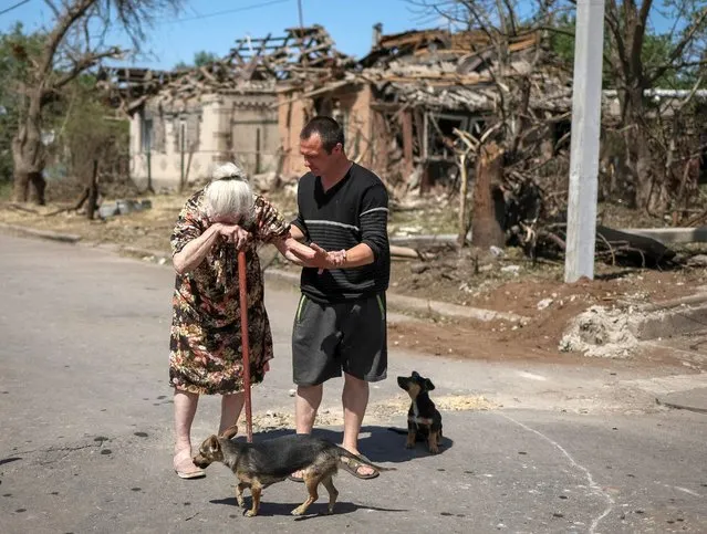 A local resident Elena, 81, reacts as she leaves her building destroyed by Russian military strike, amid Russia's invasion on Ukraine, in the town of Druzhkivka, in Donetsk region, Ukraine on June 6, 2022. (Photo by Gleb Garanich/Reuters)