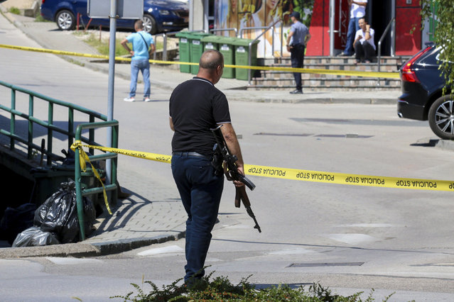 A plain-clothes police officer holds a rifle as they launch a major chase for a man who claimed to have shot and killed his wife while broadcasting it live on Instagram, in the small town of Gradacac, Bosnia, Friday, August 11, 2023. (Photo by AP Photo/Stringer)