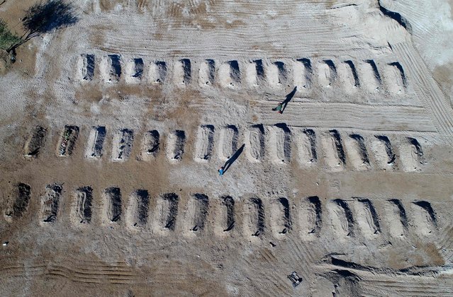 This photograph taken on May 4, 2024 shows an aerial view of graves digged on the section of a cemetery during the funeral ceremony of the victims of a bus accident in Molepolole, Botswana. A bus plunged off a bridge into a ravine and caught fire on March 28, 2024 in South Africa, killing 45 of the 46 people on board. The vehicle carrying Easter pilgrims had been heading from Molepolole in the neighbouring Botswana to Moria in the north of South Africa, the transport ministry said in a statement. (Photo by Monirul Bhuiyan/AFP Photo)