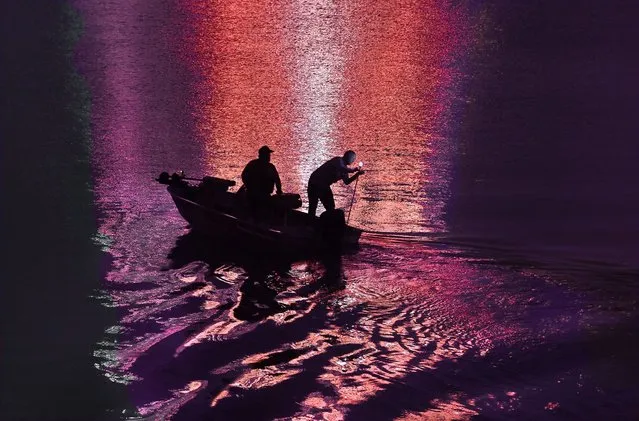 A pair of boaters leaving Riley's Lock are silhouetted by a fireworks show occurring above them in Virginia across the Potomac River in Poolesville, Maryland on July 03, 2022. A private fireworks show was on view at the Trump National Golf Club in Sterling, Virginia but plenty of Maryland folks got to see it also. (Photo by Michael S. Williamson/The Washington Post)