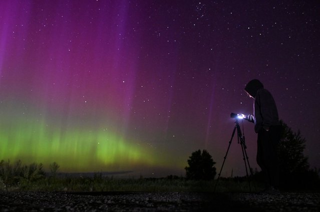 The Aurora Borealis, also known as the “Northern Lights”, illuminate the sky as people gather to watch the annual Perseid meteor shower near the village of Borodinka in the Omsk region, Russia on August 13, 2024. (Photo by Alexey Malgavko/Reuters)