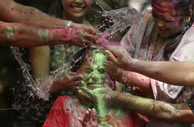 People throw water and smear coloured powder on a woman during Holi celebrations in Mumbai, India, March 10, 2020. (Photo by Francis Mascarenhas/Reuters)