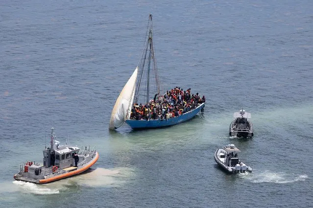 Law enforcement officials along with U.S. Coast Guard sail near a sailboat containing approximately 150 migrants on July 21, 2022 in Islandia, Florida. U.S. Coast Guard, Miami-Dade police and other law enforcement agencies are processing the migrants after they were intercepted near Boca Chita Key Thursday morning. (Photo by Joe Raedle/Getty Images)