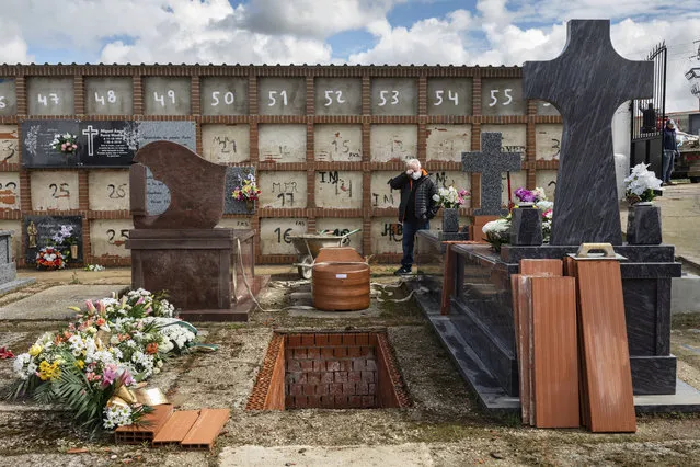 Eusebio Fernandez Cortes, 59, attends the burial of his mother Rosalia Mascaraque, 86, during the coronavirus outbreak in Zarza de Tajo, central Spain, Wednesday, April 1, 2020. Fernandez lost both of his parents within the same week due COVID-19. Intensive care units are particularly crucial in a pandemic in which tens of thousands of patients descend into acute respiratory distress. (Photo by Bernat Armangue/AP Photo)