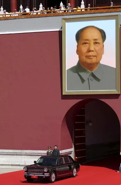 Chinese President Xi Jinping stands in a car driving past the giant portrait of Chinese late chairman Mao Zedong, on his way to inspect the army, at the beginning of the military parade marking the 70th anniversary of the end of World War Two, in Beijing, China, September 3, 2015. (Photo by Reuters/Stringer)
