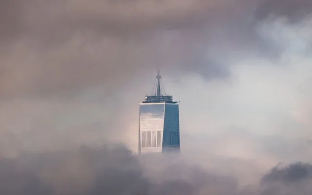 The top of One World Trade Center in the clouds in New York, New York, USA, 12 September 2022. (Photo by Justin Lane/EPA/EFE)
