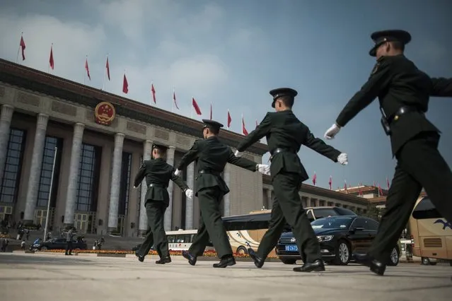 Chinese paramilitary guards walk in front of the Great Hall of the People during the Communist Party's 19th Congress in Beijing on October 19, 2017. The Chinese Communist Party opens its week-long, twice-a-decade congress in the Great Hall of the People. (Photo by Fred Dufour/AFP Photo)