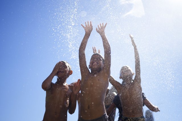 Children play in the spray of a water hose during summer in Buenos Aires, Argentina, January 13, 2025. (Photo by Natacha Pisarenko/AP Photo)