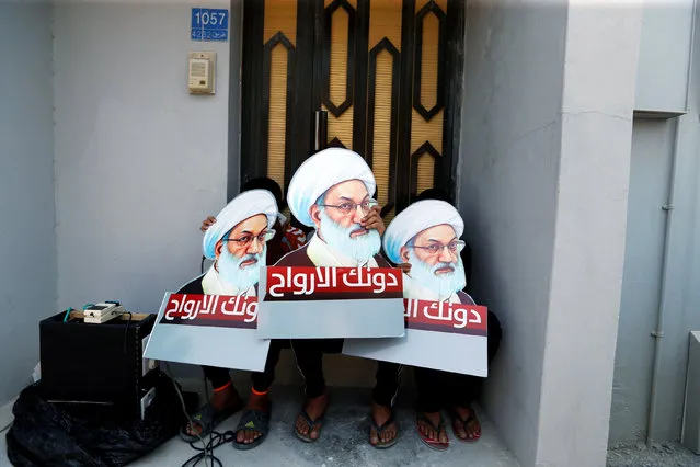 Protesters holding placards with images of Bahrain's leading Shi'ite cleric Isa Qassim, shout religious slogans during an anti-government protest after Friday prayers in the village of Diraz, west of Manama, Bahrain August 12, 2016. The placards read, “We sacrifice our souls for you”. (Photo by Hamad I Mohammed/Reuters)