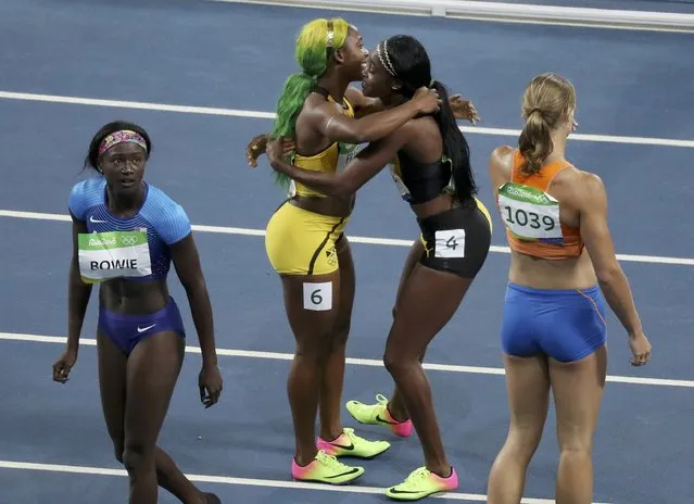 2016 Rio Olympics, Athletics, Final, Women's 100m Final, Olympic Stadium, Rio de Janeiro, Brazil on August 13, 2016. Shelly Ann Fraser-Pryce (JAM) (2nd-L) of Jamaica, winner of the bronze medal, is embraced by gold medal winner Elaine Thompson (JAM) of Jamaica  after the women's 100 meters. (Photo by Carlos Barria/Reuters)