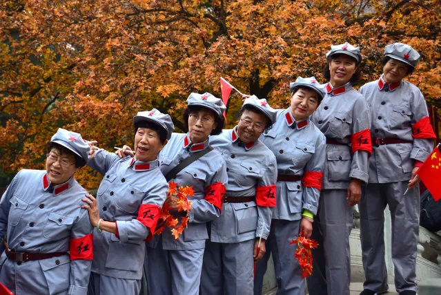 Women in replica red army uniforms have their picture taken as autumn leaves cover maple trees in Fragrant Hills Park in Beijing, China October 27, 2017. (Photo by Reuters/China Stringer Network)