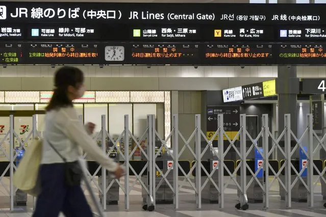 A person walks past closed ticket gates at train station in Hiroshima, western Japan, Monday September 19, 2022. Powerful Typhoon Nanmadol slammed ashore in southern Japan on Sunday as it pounded the region with strong winds and heavy rain, causing blackouts, paralyzing ground and air transportation and prompting the evacuation of thousands of people. (Photo by Kyodo News via AP Photo)