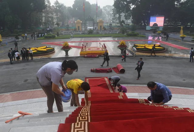 Workers lay down red carpet prior to the welcoming ceremony for U.S. President Donald Trump at the presidential palace in Hanoi, Vietnam Sunday, November 12, 2017. (Photo by Hoang Dinh Nam/Pool Photo via AP Photo)