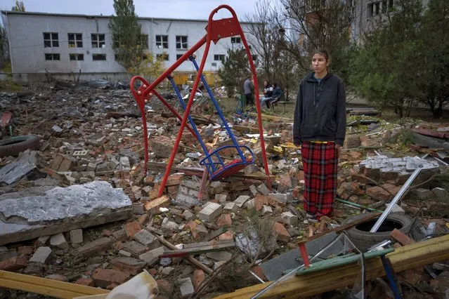 Taisiia Kovaliova, 15, stands amongst the rubble of a playground in front of her house hit by a Russian missile in Mykolaiv, Sunday, October 23, 2022. “I spent all my childhood and life at this courtyard, I already feel nostalgic. I went to this swing that stood it all” Taisiia said. (Photo by Emilio Morenatti/AP Photo)