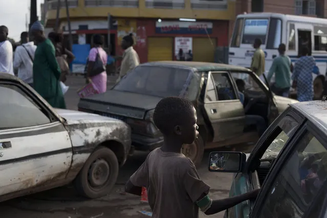 In this file photo September 24, 2013 photo, a “talibe” begs for change from a driver stopped at a gas station, in the Medina Gounass suburb of Dakar, Senegal. More than 500 such children have been taken from Dakar's streets in the past two months. President Macky Sall announced the crackdown in June, 2016, and said the government will prosecute, fine and jail parents or Quranic teachers, known as marabouts, who are found guilty of abuses. (Photo by Rebecca Blackwell/AP Photo)