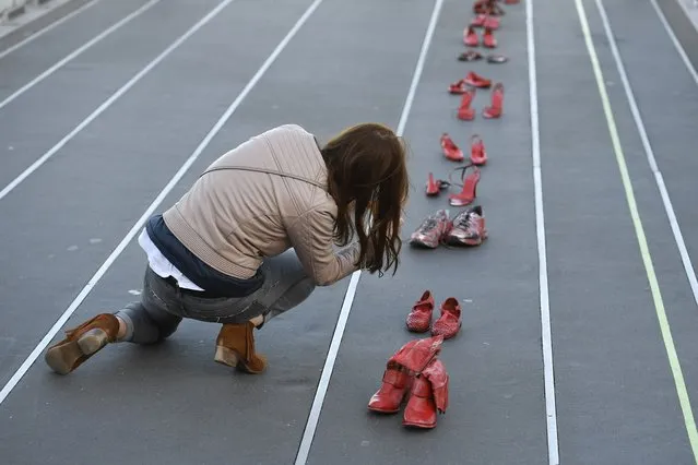 A picture taken on November 25, 2017 shows red-painted shoes, symbolizing all the women victims of domestic violence, harassment, rape, sexual assault or feminicide, during a demonstration near the courthouse of Nantes during the International Day for the Elimination of Violence Against Women. (Photo by Damien Meyer/AFP Photo)
