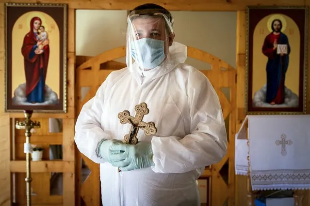 In this photo taken on Thursday, May 28, 2020, Ukrainian Greek Catholic Church priest, Father Yaroslav Rokhman wearing protective gear to protect against coronavirus, poses for a photo at a hospice in Ivano-Frankivsk, Ukraine.  Rokhman, a priest in the Ukrainian Greek Catholic Church, is pleased to be able to return to performing one of a cleric's most heartfelt duties. As the coronavirus pandemic's grip on Ukraine slowly recedes, priests received permission on May 22 to again hold services and visit the sick. (Photo by Evgeniy Maloletka/AP Photo)