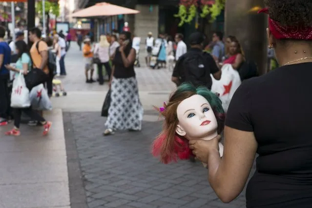 A woman carries a mannequin head through Downtown Crossing in Boston, Massachusetts, September 1, 2015. (Photo by Brian Snyder/Reuters)