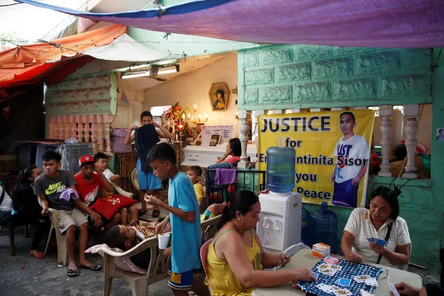 Relatives and friends play cards and gather at the wake of Eric Quintinita Sison in Pasay city, Metro Manila in the Philippines August 29, 2016. Family members of Sison said he was attempting to surrender when he was gunned down by the police during a recent “Meth” buy bust operation in Pasay city. (Photo by Erik De Castro/Reuters)