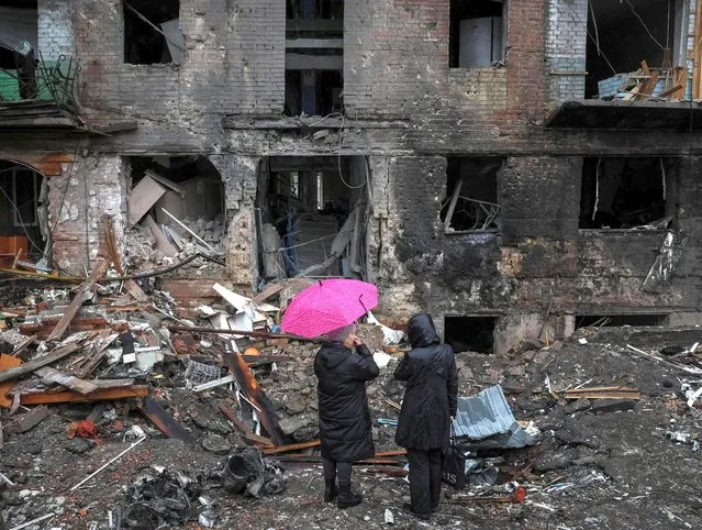 Local residents stand near their building destroyed by a Russian missile attack, as Russia's attack on Ukraine continues, in the town of Vyshhorod, near Kyiv, Ukraine on November 24, 2022. (Photo by Gleb Garanich/Reuters)