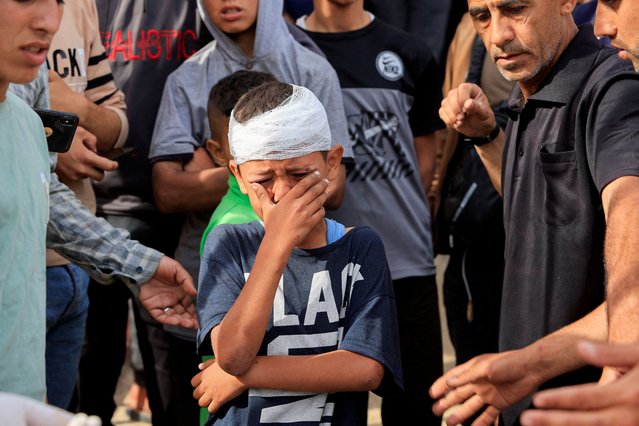 Injured Palestinian child, Yousef Al-Bayouk, weeps over his brothers, Moath and Moataz, who were killed in Israeli strikes, as mourners attend their funeral, at Nasser hospital in Khan Younis, southern Gaza Strip, on May 15, 2025. (Photo by Hatem Khaled/Reuters)