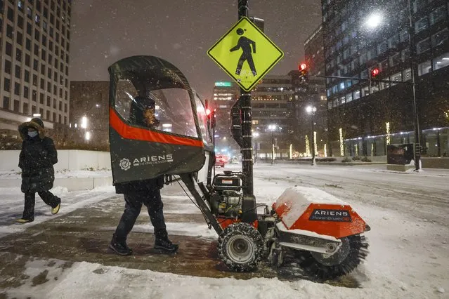 A man uses a snow blower to clear a sidewalk during a winter storm ahead of the Christmas Holiday outside the Union Station, in Chicago on December 22, 2022. More than 2,200 flights were canceled across the United States by Thursday afternoon as a massive winter storm named Elliot upended holiday travel plans with a triple threat of heavy snow, howling winds and bitter cold (Photo by Kamil Krzaczynski/AFP Photo)