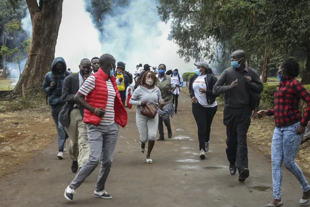 Demonstrators run from teargas fired by police at a protest against alleged corruption, including the theft of supplies for the fight against the coronavirus, at Uhuru Park in downtown Nairobi, Kenya Friday, August 21, 2020. Kenya's police teargassed and arrested some of the protesters who were holding a peaceful demonstration following the announcement that the country's anti-corruption agency is investigating the theft of millions of dollars of supplies from the Kenya Medical Supplies Authority. (Photo by AP Photo/Stringer)