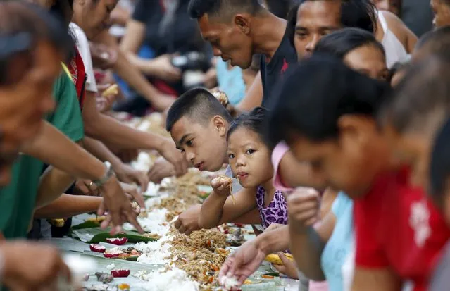 Supporters of Philippine Vice President Jejomar Binay (not pictured) eat "boodle style" breakfast before Binay and his running mate Senator Gregorio Honasan file their Certificates of Candidacy (COC) for President and Vice-President for May 2016 national elections, at the Commission on Elections in Manila October 12, 2015. (Photo by Erik De Castro/Reuters)