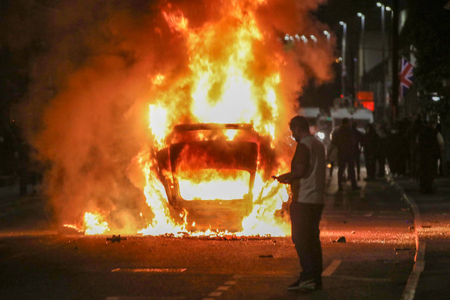 A vehicle is set alight during an anti-immigration demonstration in Ballymena, Northern Ireland, on June 10, 2025. Violence flared for a second night June 10 in the Northern Irish town of Ballymena after “racially motivated” attacks sparked by the arrest of two teenagers accused of the attempted rape of a young girl. Hundreds of protestors, many of them masked, took to the streets of Ballymena, throwing petrol bombs and masonry as police responded with water cannon, an AFP journalist said. (Photo by Paul Faith/AFP Photo)
