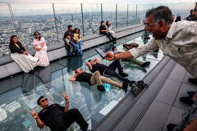 Tourists pose as they enjoy the Mahanakhon Skywalk Rooftop at Mahanakhon building in Bangkok, Thailand, on May 15, 2025. (Photo by Athit Perawongmetha/Reuters)