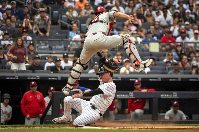 New York Yankees' Cody Bellinger, bottom, is tagged out at home plate by Philadelphia Phillies catcher J.T. Realmuto, top, during the third inning of a baseball game, Sunday, July 27, 2025, in New York. (Photo by Angelina Katsanis/AP Photo)