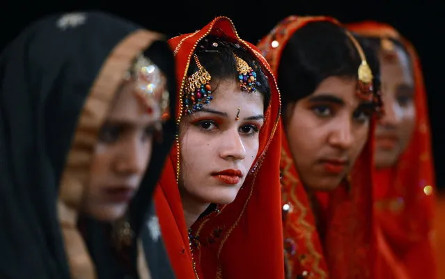 Pakistani brides attend a mass marriage ceremony in Karachi late March 26, 2013.  Some 110 couples participated in the mass wedding ceremony organised by a local charity welfare trust Al Ghousia. (Photo by Asif Hassan/AFP Photo)