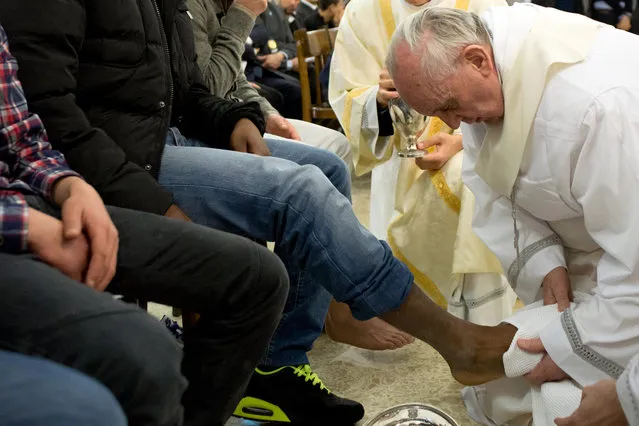 In this photo provided by the Vatican newspaper L'Osservatore Romano, Pope Francis washes the foot of an inmate at the juvenile detention center of Casal del Marmo, Rome, Thursday, March 28, 2013. Francis washed the feet of a dozen inmates at a juvenile detention center in a Holy Thursday ritual that he celebrated for years as archbishop and is continuing now that he is pope. Two of the 12 were young women, an unusual choice given that the rite re-enacts Jesus' washing of the feet of his male disciples. The Mass was held in the Casal del Marmo facility in Rome, where 46 young men and women currently are detained. Many of them are Gypsies or North African migrants, and the Vatican said the 12 selected for the rite weren't necessarily Catholic. (Photo by L'Osservatore Romano/AP Photo)