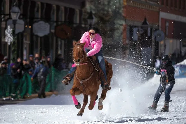 Savannah McCarthy, 23, of Durango, Colorado races down harrison Avenue on her horse Money while pulling skier Brennen Counsell during the 75th annual Leadville Ski Joring weekend competition on March 5, 2023 in Leadville, Colorado. McCarthy often teams up with elite skiers and is an eight time Open Division winner, leading to her nickname The Queen of Harrison. Skijoring, which has its origins as a competitive sport in Scandinavia, has been adapted over the years to include a team made up of a rider and skier who must navigate jumps, slalom gates, and the spearing of rings for points. Leadville, with an elevation of 10,152 feet (3,094 m), the highest incorporated city in North America, has been hosting skijoring competitions since 1949. (Photo by Jason Connolly/AFP Photo)