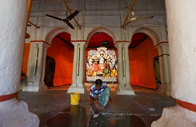 A worker cleans the floor after installing the idol of Durga at a platform inside a home, during the Durga Puja festival in Kolkata, India, October 7, 2016. (Photo by Rupak De Chowdhuri/Reuters)
