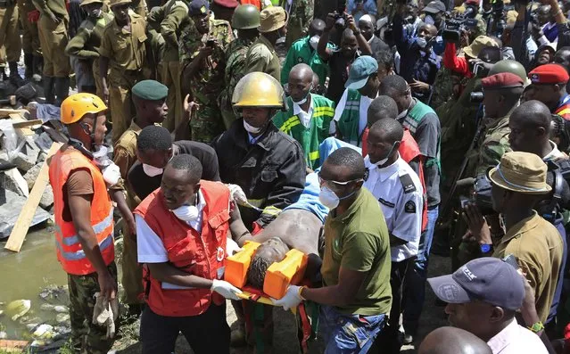 Rescuers carry a survivor from the rubble of a collapsed residential building in Makongeni estate in Kenya's capital Nairobi December 17, 2014. (Photo by Noor Khamis/Reuters)