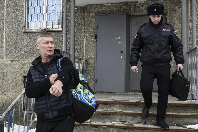 Yevgeny Roizman, former mayor of Russia's fourth-largest city, walks escorted by a police officer in Yekaterinburg, Russia, Thursday, March 16, 2023. Roizman has been detained on charges that could land him behind bars as part of authorities' efforts to muzzle dissent. Yevgeny Roizman is a sharp critic of the Kremlin and one of the most visible and charismatic opposition figures in Russia. (Photo by Vladimir Podoksyonov/AP Photo)