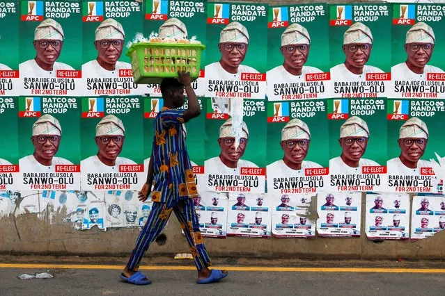 A street vendor walks past campaign posters of Lagos state gubernatorial candidate of the ruling All Progressives Congress (APC) Babajide Sanwo-Olu, during the gubernatorial election in Lagos, Nigeria on March 18, 2023. (Photo by Temilade Adelaja/Reuters)