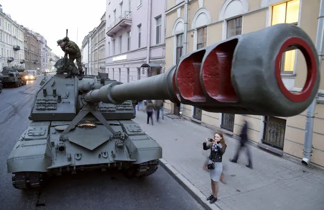 A woman takes a photo of the Self-propelled artillery vehicle Msta S prior to a rehearsal for the Victory Day military parade which will take place at Dvortsovaya (Palace) Square on May 9 to celebrate 73 years after the victory in WWII, in St.Petersburg, Russia, Monday, April 30, 2018. (Photo by Dmitri Lovetsky/AP Photo)