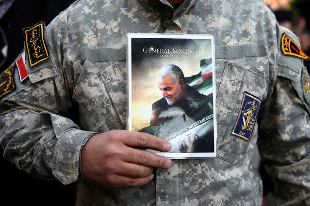 A demonstrator holds the picture of Qassem Soleimani during a protest against the assassination of the Iranian Major-General Qassem Soleimani, head of the elite Quds Force, and Iraqi militia commander Abu Mahdi al-Muhandis who were killed in an air strike in Baghdad airport, in Tehran, Iran January 3, 2020. (Photo by Nazanin Tabatabaee/WANA (West Asia News Agency) via Reuters)
