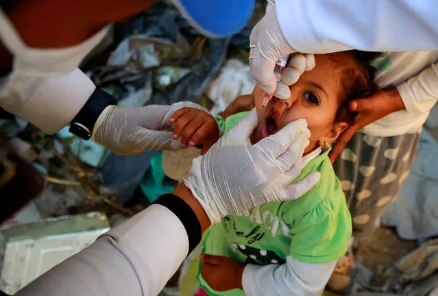 A girl receives a polio vaccine during a three-day immunization campaign in Sanaa, Yemen on November 29, 2020. (Photo by Nusaibah Almuaalemi/Reuters)