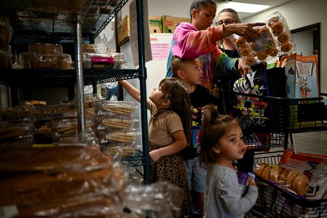 Lidia Gelnett and her children, Lucy, 4, Leo, 6, and Lyanna Styles, 2, select desserts at Connections 4 Life food pantry, weeks into the continuing U.S. government shutdown, in Fountain, Colorado, on November 7, 2025. (Photo by Mark Makela/Reuters)