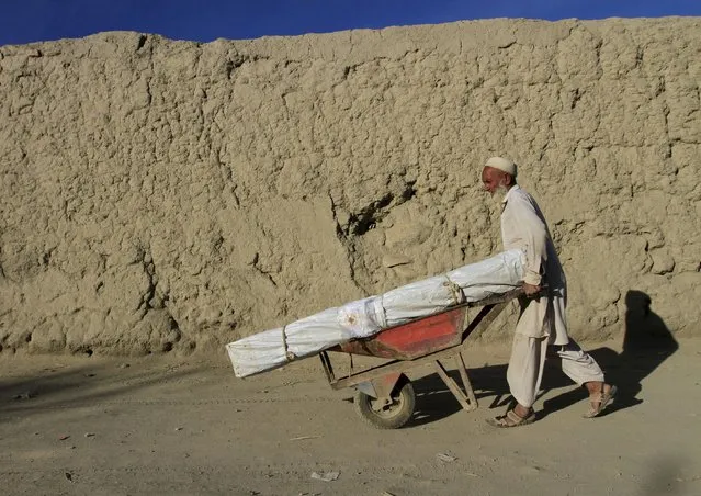 An Afghan man uses a wheelbarrow to move aid he received from the International Federation of the Red Cross and Red Crescent Societies after an earthquake, in Rodat district of Jalalabad province, Afghanistan October 29, 2015. The Taliban urged aid agencies on Tuesday to push ahead in delivering emergency relief supplies after a major earthquake hit remote mountainous regions of northern Afghanistan and Pakistan. (Photo by Reuters/Parwiz)
